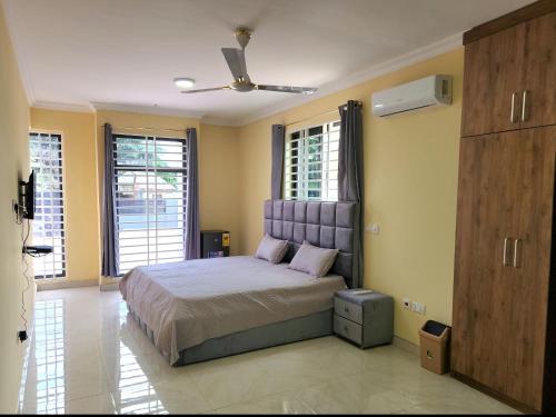 een slaapkamer met een bed in een kamer met ramen bij Jab Duplex X in Adentan