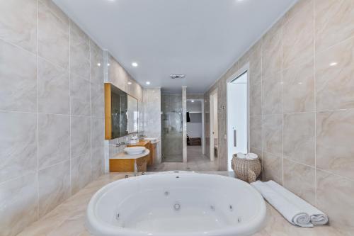 a large bathroom with a tub and a sink at Pavilions 9 & Buggy - Hamilton Island in Hamilton Island