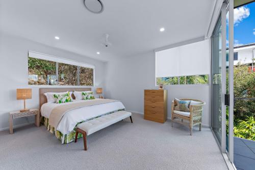 a white bedroom with a bed and a window at Pavilions 9 & Buggy - Hamilton Island in Hamilton Island