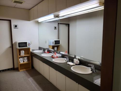 a bathroom with three sinks and a large mirror at Matsupokkuri in Zaō Onsen