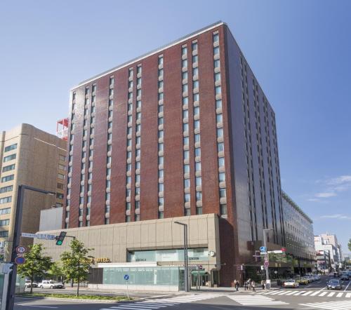 un grand bâtiment en briques sur une rue de la ville dans l'établissement Sapporo Grand Hotel, à Sapporo