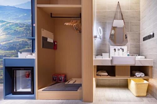 a bathroom with a sink and a mirror at Atour Hotel Chongqing Guanyinqiao Flower Garden in Chongqing