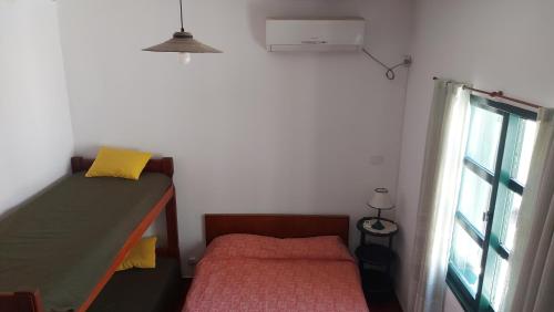 a small bedroom with a bed and a window at Castillo Del Lago - Carlos Paz - D26 in Villa Carlos Paz