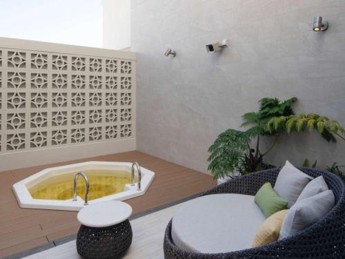 a living room with a table and a bath tub at Okinawa Hinode Resort and Hot Spring Hotel in Naha