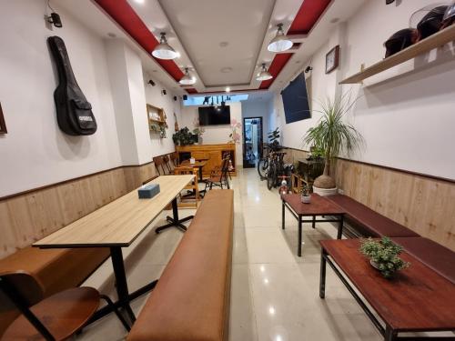un restaurante con mesas y sillas y una guitarra en la pared en Tiny Tigers Hostel en Da Lat