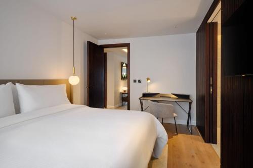a bedroom with a white bed and a desk at The Westin London City in London