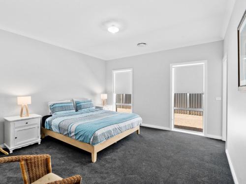 a white bedroom with a bed and a window at Sunsets by the Lake in Yarrawonga