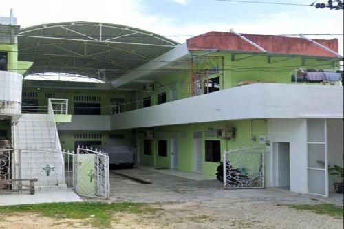 a building with green and white at OYO 93340 Angsana Aglow Homestay in Duri