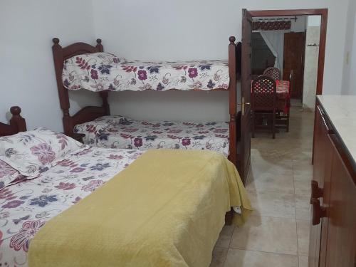 a bedroom with two bunk beds with a yellow blanket at Hospedaje Lupé in Cachí