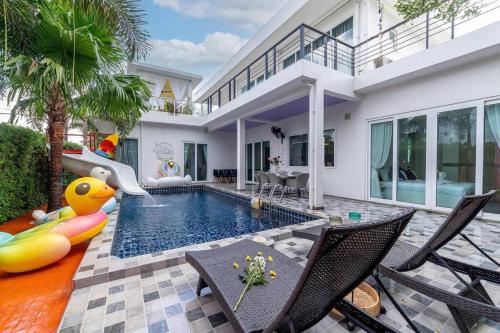 a house with a swimming pool with a pool slide at Luxurious and Playful 5 Bedroom Pool Villa - CC in Na Jomtien