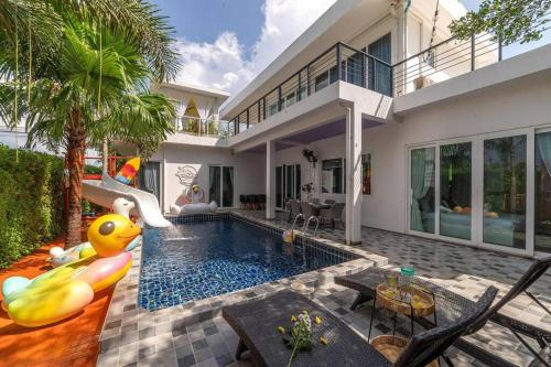 a house with a swimming pool with a inflatable pool noodle at Luxurious and Playful 5 Bedroom Pool Villa - CC in Na Jomtien