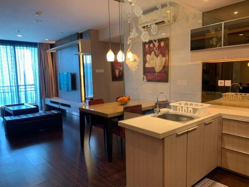 a large kitchen with a sink and a table at 2br- Central Park Residence Alaina Tower Floor 29 in Jakarta