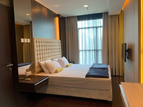 a bedroom with a large bed with a window at 2br- Central Park Residence Alaina Tower Floor 29 in Jakarta