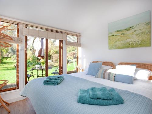 a bedroom with two beds with towels on them at Flaxpool Well Garden Room in Crowcombe