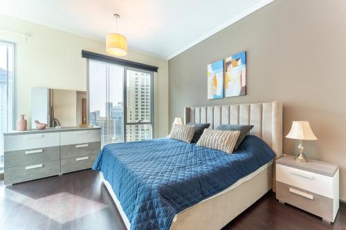 a bedroom with a blue bed and a large window at Dubai Marina Apartment with Sea view, Pool and Gym in Dubai