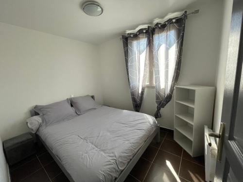 a small bedroom with a bed and a window at Les maisonnettes de bonneval in Jaujac