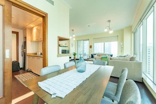 a dining room and living room with a table and chairs at Dubai Marina Apartment with Sea view, Pool and Gym in Dubai