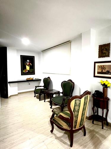 um quarto com cadeiras, uma mesa e uma janela em Tomasa guest house em Bogotá