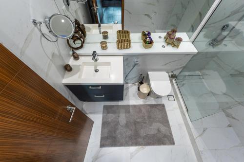 a bathroom with a sink and a toilet and a mirror at Dubai Marina Apartment with Sea view, Pool and Gym in Dubai