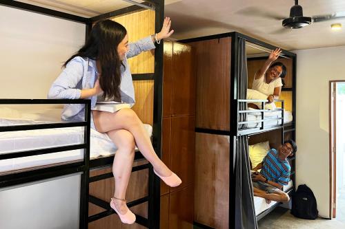 a girl is sitting on top of a bunk bed at Abraham Bohol in Panglao Island