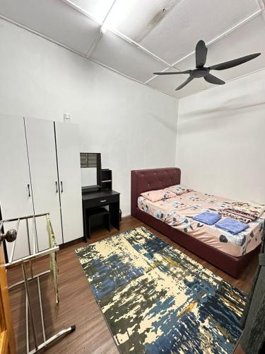 a bedroom with a bed and a ceiling fan and a rug at nd homestay in Kuala Lipis