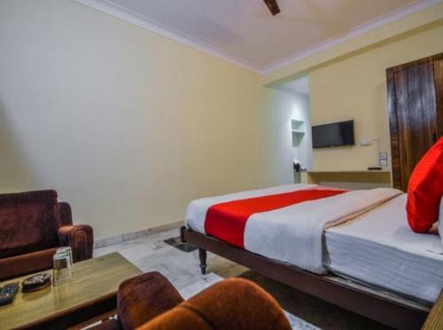 Hotel Vinayakam في أودايبور: غرفة نوم بسرير واريكة وطاولة