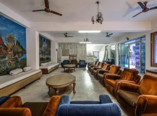 Hotel Vinayakam في أودايبور: غرفة معيشة كبيرة مع كنب وطاولة