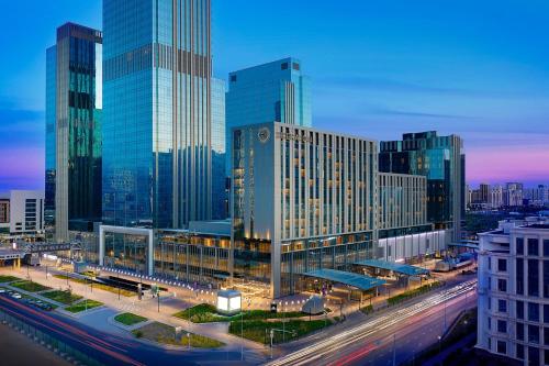 a city skyline with tall buildings and a freeway at Sheraton Astana Hotel in Astana