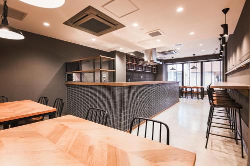 a restaurant with tables and chairs and a bar at WAYFARER Shinsaibashi in Osaka
