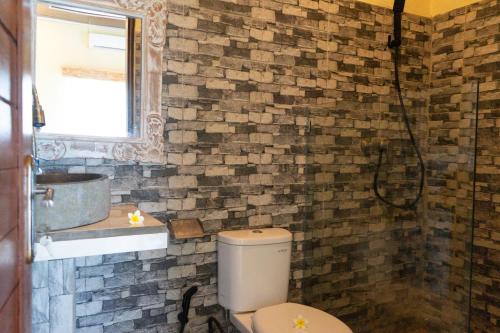 a bathroom with a toilet and a sink at KRISNA TAPAN GUEST HOUSE in Ubud