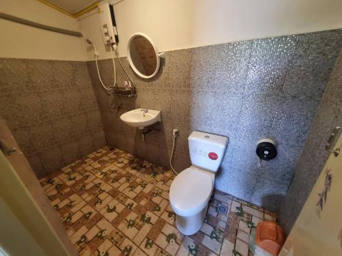 La salle de bains est pourvue de toilettes et d'un lavabo. dans l'établissement บ้านสวน สระแก้ว รีสอร์ท, 