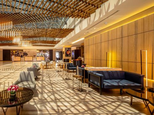 a lobby with couches and chairs and tables at Flora Inn Hotel Dubai Airport in Dubai