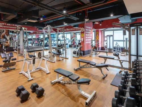 a gym with several treadmills and weights at Flora Inn Hotel Dubai Airport in Dubai