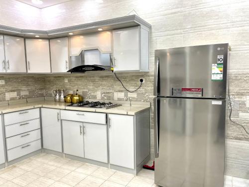 a kitchen with white cabinets and a stainless steel refrigerator at Traveler Rooms 2 in Medina