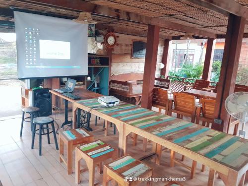 a room with a large wooden table and chairs at Kedthawa Homestay เฮือนเก็ดถะหวา in Ban Cho Lae