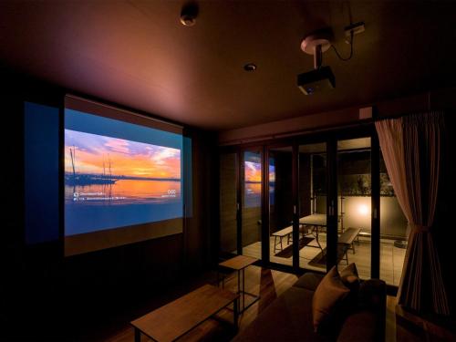 a living room with a large flat screen tv on the wall at Rakuten STAY Nikko Hoden Capacity of 4 persons in Nikko