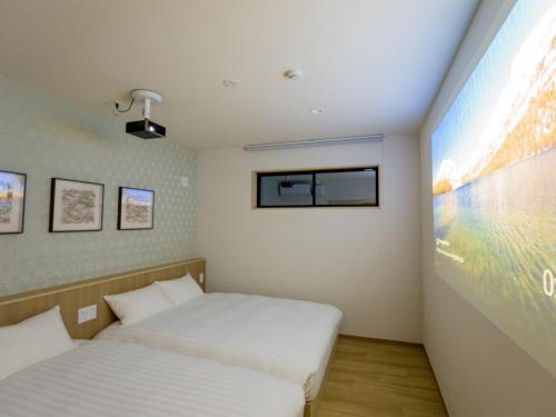 a bedroom with two beds and a large screen at Rakuten STAY Nikko Hoden Capacity of 8 persons in Nikko