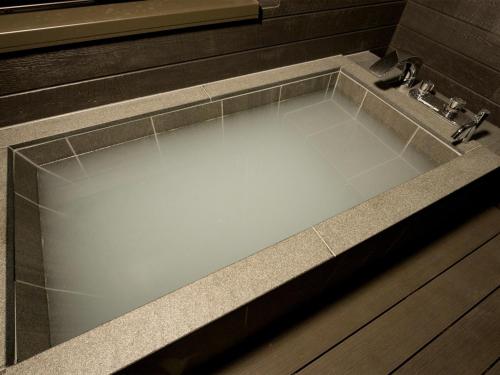 Rakuten STAY Nikko Hoden Capacity of 8 persons في نيكو: حوض استحمام مع حوض في الحمام