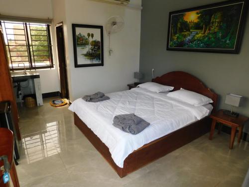 a bedroom with a large bed with white sheets at Tom's Place in Siem Reap