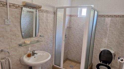 a bathroom with a shower and a sink and a toilet at Grenadier A in Flic-en-Flac