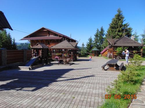 a park with a playground with a building with a slide at Panorama Karpat in Yablunytsya