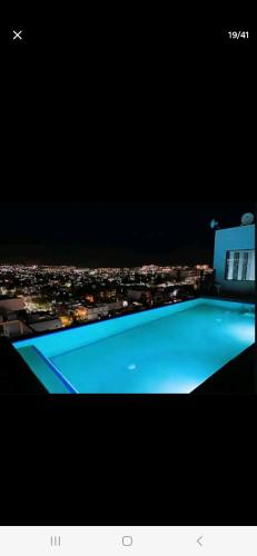 a swimming pool with a view of a city at night at Elegant Condo in an Upscale Building in Cabo San Lucas