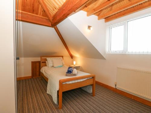 een slaapkamer met een bed en een raam bij Coed Llai in Holyhead