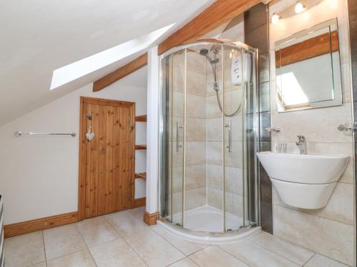 een badkamer met een douche en een wastafel bij Coed Llai in Holyhead