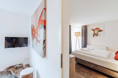 ein weißes Schlafzimmer mit einem Bett und einem Spiegel in der Unterkunft Apartment BERGsucht - modern, gemütlich, zentrale, ruhige Lage in Schliersee