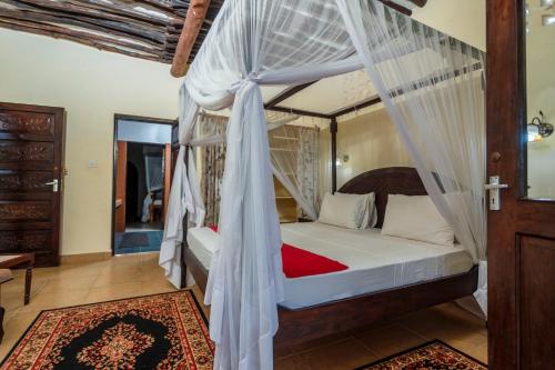 a bedroom with a canopy bed with mosquito nets at Diani Beach-Villa Kirsch in Galu