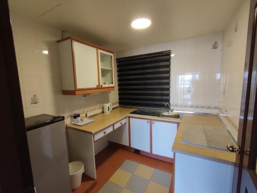 a small kitchen with a sink and a refrigerator at Sunrise View One Bedroom Apartment at Equatorial Hill Resort in Brinchang