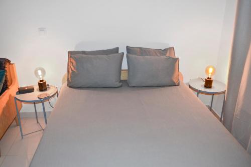 uma cama num quarto com duas mesas de cabeceira em AP2B Praia em Praia