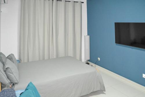 a bedroom with a bed and a flat screen tv at AP2B Praia in Praia
