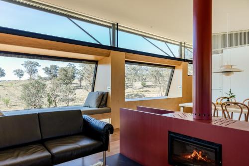 a living room with a fireplace and a couch at Strikes 3 in Eurunderee